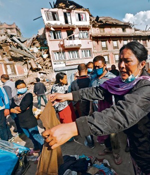 Victims walk along a street next to collapsed houses in Sankhu, on the outskirts of Kathmandu, yesterday.  Picture: Alet Pretorious