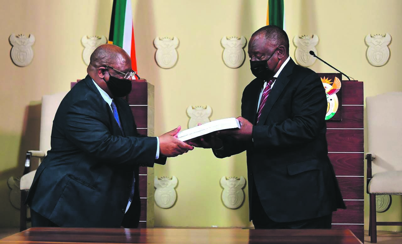 At the Union Buildings in Pretoria on Tuesday, acting Chief Justice Raymond Zondo hands the first part of his state capture report to President Cyril Ramaphosa. Photo: GCIS
