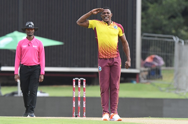 West Indian fast bowler Sheldon Cottrell celebrates a wicket with his signature salute.