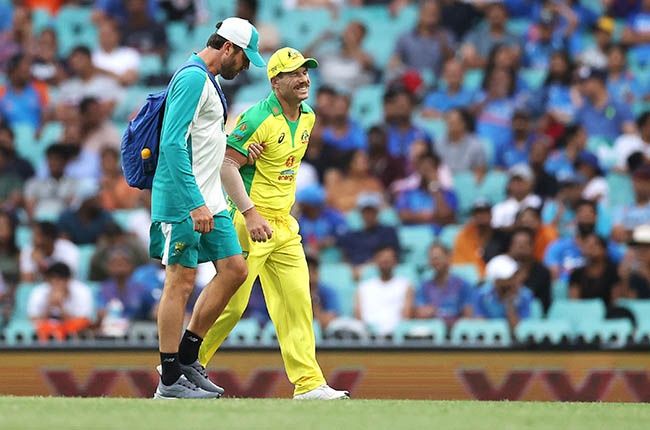 Australia’s David Warner is assisted from the field after injuring himself against India at the Sydney Cricket Ground on 29 November 2020.
