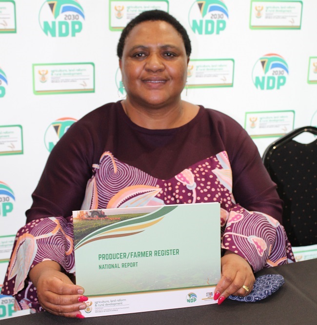 Me. Thoko Didiza, minister van landbou, grondhervorming en landelike ontwikkeling, met ’n afskrif van die nasionale verslag oor die register vir boere. Foto: Nico van Burick