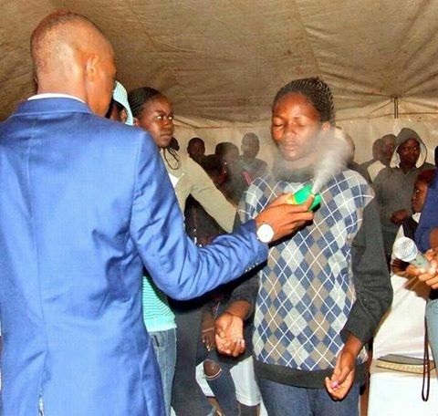 Pastor Lethebo Rabalago of Mount Zion General Assembly is seen spraying insecticide in congregants’ faces. Picture: facebook 
