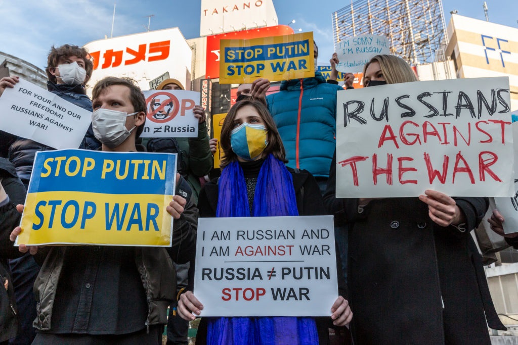 People hold placards during a protest against Russia's attack on Ukraine in front of Shinjuku station on February 26, 2022 in Tokyo, Japan. 