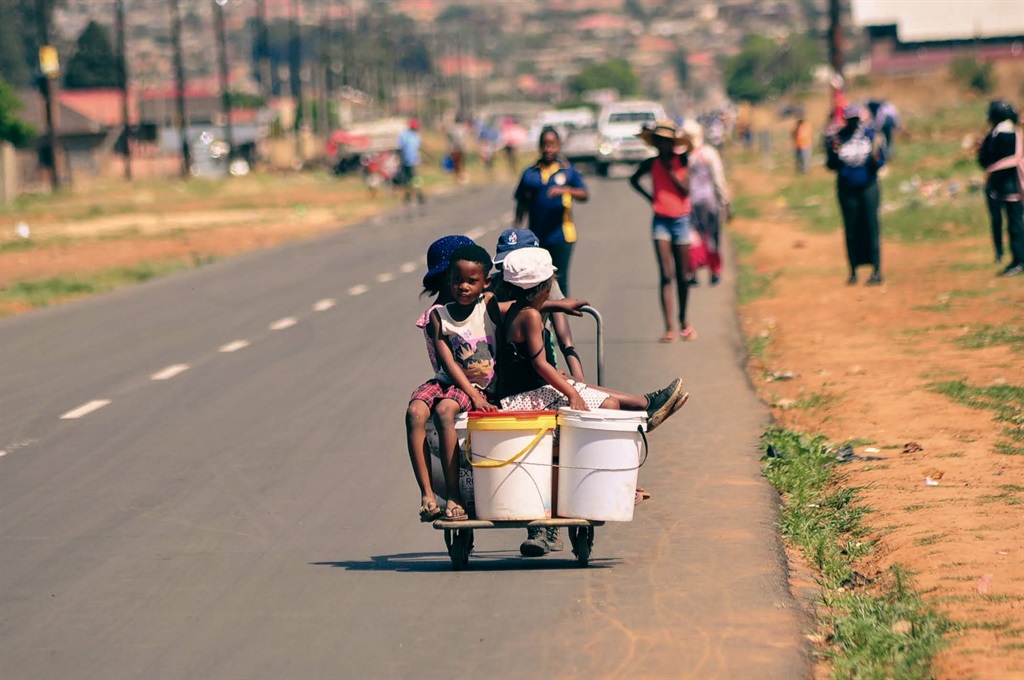 Children sit on buckets in a township. Photo: Alfonso Nqunjana/News24