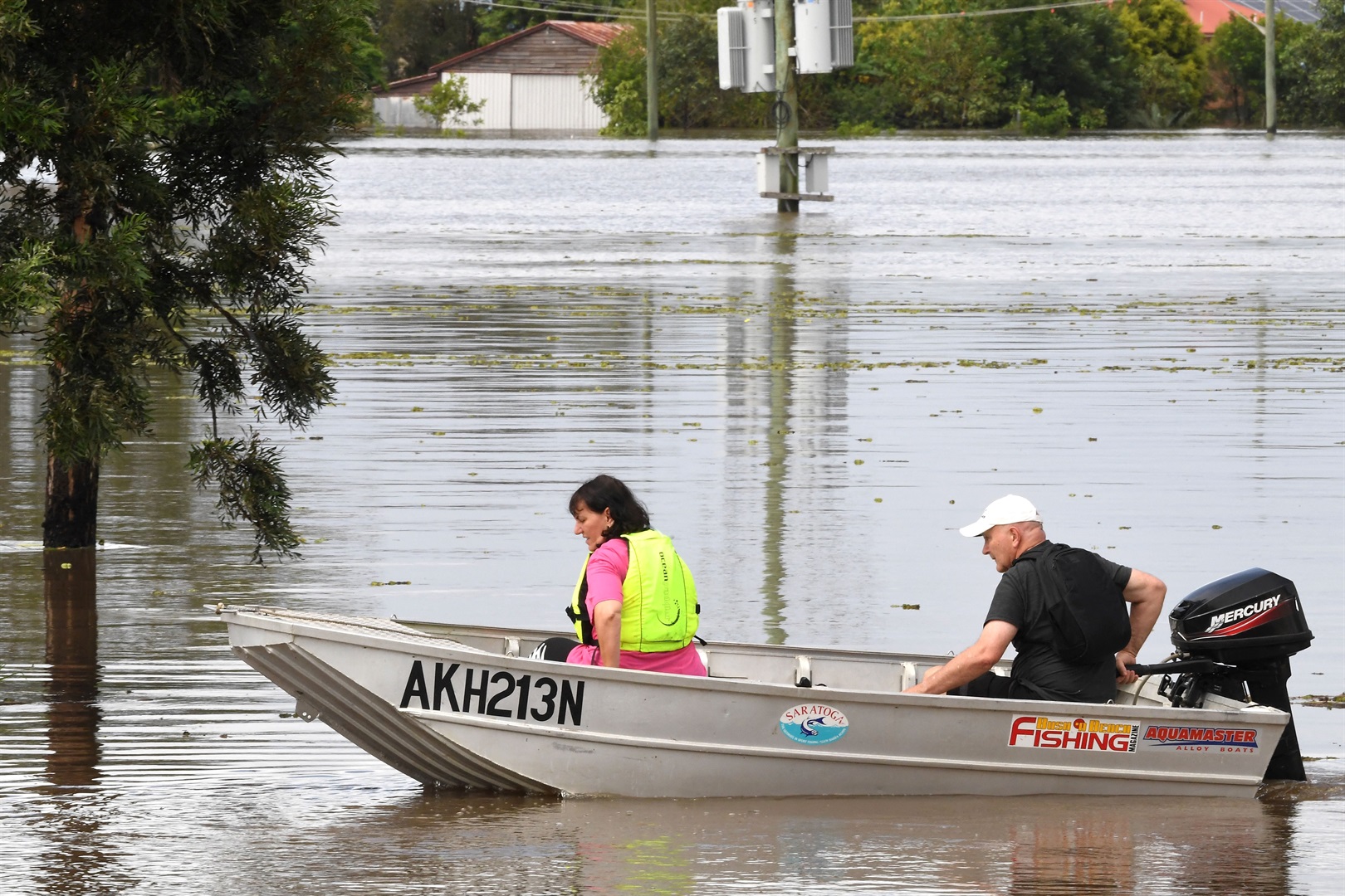 A family steers their boat through a flooded street in the New South Wales suburb of Lawrence. SAEED KHAN/AFP via Getty Images