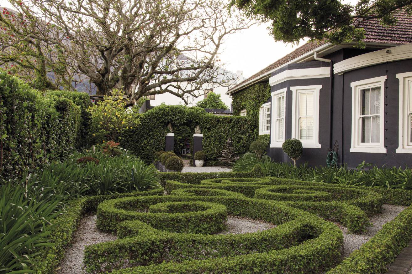 The spiral pattern formed by the dune crowberry hedge complements the curvature of the house and adds structure to the spacious front garden. Karin du Plessis and her team from In & Outdoor Gardens planted the low hedge and are responsible for maintaining and pruning it (turn to page 117 to see how she created this design). “I felt that since the front garden is so big, it needs an impressive element,” says Marti. Her house is located quite far back on the property behind large trees. As the shape of the house wasn’t really to her liking, she wanted it to disappear. “The black on the exterior makes it recede and enhances the greenery in the garden,” she says. “It almost gives the garden a dark forest feel.