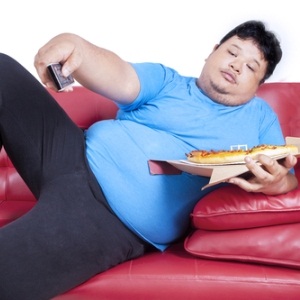 Obese man on couch from Shutterstock