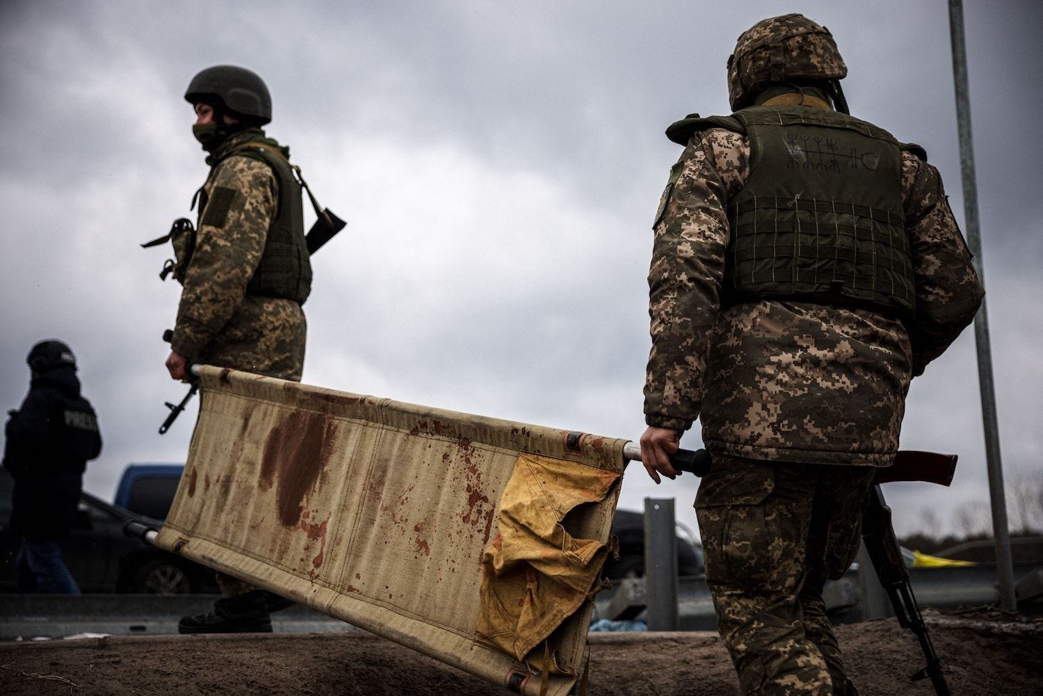 Ukrainian troops with a blood-stained stretcher near the city of Irpin, northwest of Kyiv, March 13, 2022. Dimitar Dilkoff/AFP via Getty Images
