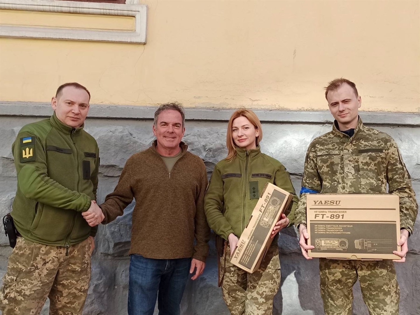 Çernivtsi'deki Ukrayna Silahlı Kuvvetleri üyeleri, soldan ikinci, Ukrayna Özgürlük Projesi'nin kurucusu Steven Moore'dan Yaesu telsizlerini kabul ediyor.  Steven Moore'un izniyle