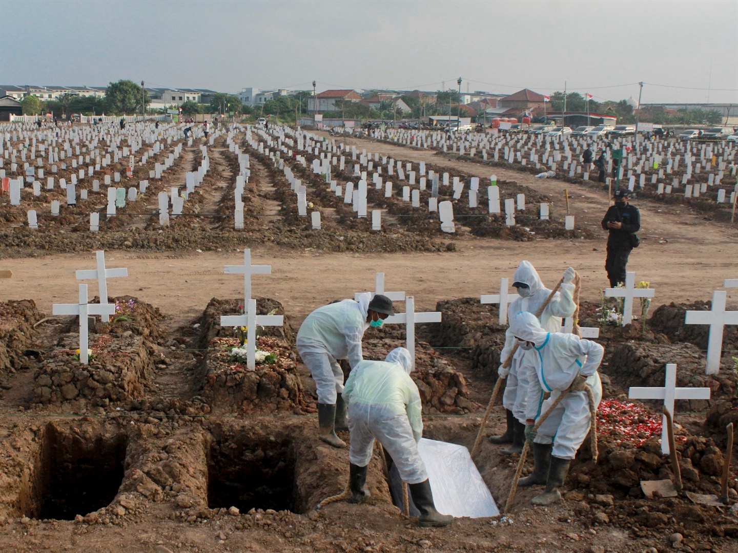 Grave officials are seen burying victims who died due to Covid-19 at a special cemetery in Rorotan, Jakarta, Indonesia on August 8, 2021.