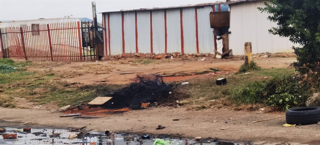The scene where an alleged thug was stoned and burned to death. Photo by Trevor Kunene. 