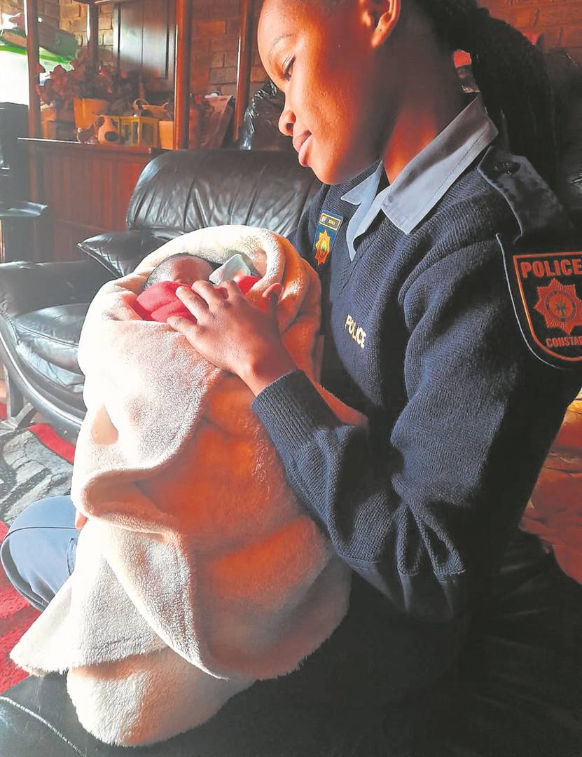 Constable Malebo Sefala holding the baby girl who was left outside a house. The mum is due to appear in court today, 13 May. 