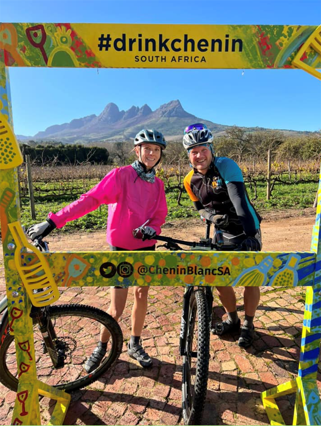 Two Mountain Bikers at the #DrinkChenin sign at Ken Forrester. 