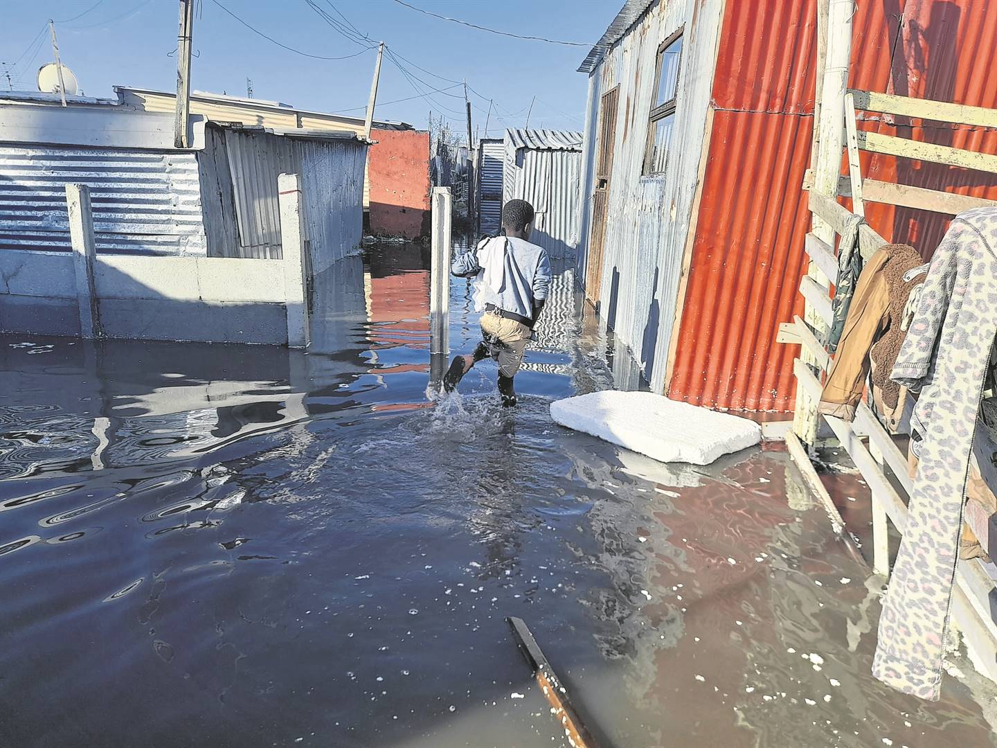 A child wades through the water after Winnie Madikizela squatter camp in Philippi was flooded last week.                                             Photo by Misheck Makora 