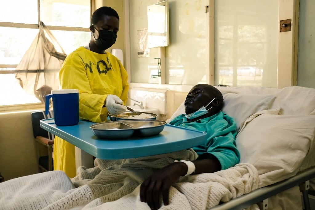 Nurse serves a meal to a patient in Harare hospital
