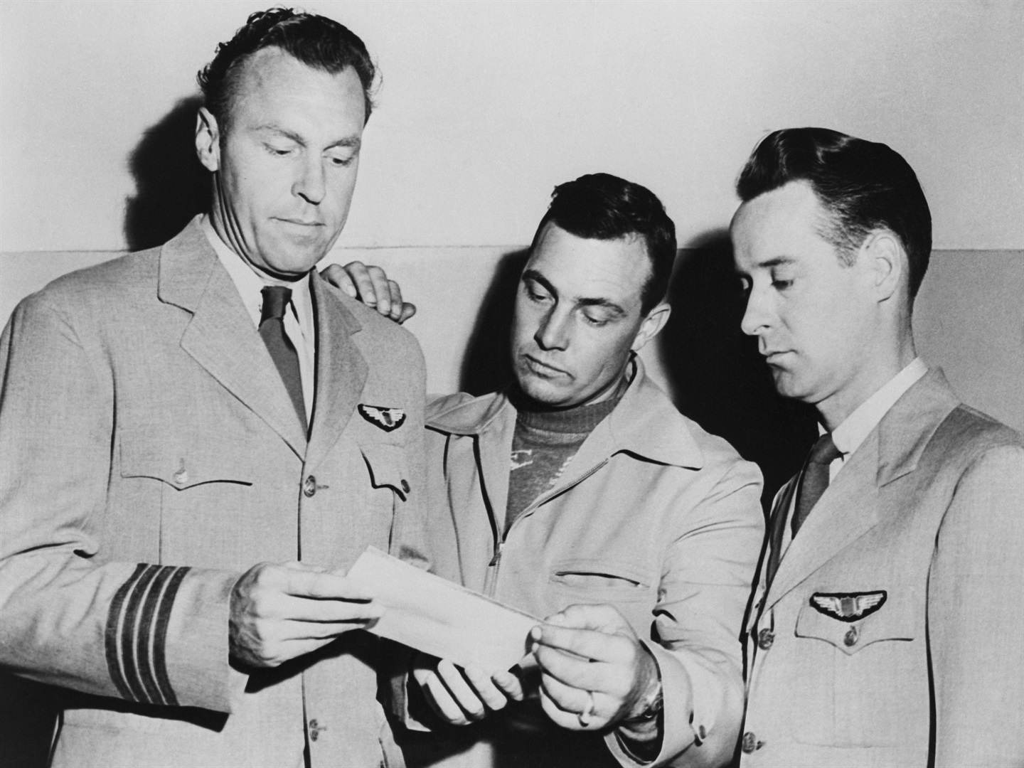 Pilotlar EJ Smith, Kenneth Arnold ve Ralph E. Stevens, 1947'de Seattle, Washington'a giderken gördükleri, tanımlanamayan bir uçan cismin fotoğrafına bakıyorlar. Bettmann/Getty Images