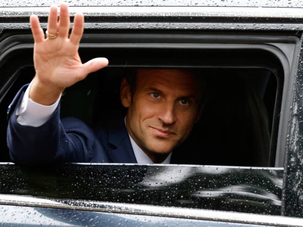 Fransa Cumhurbaşkanı Emmanuel Macron koşarken el sallıyor