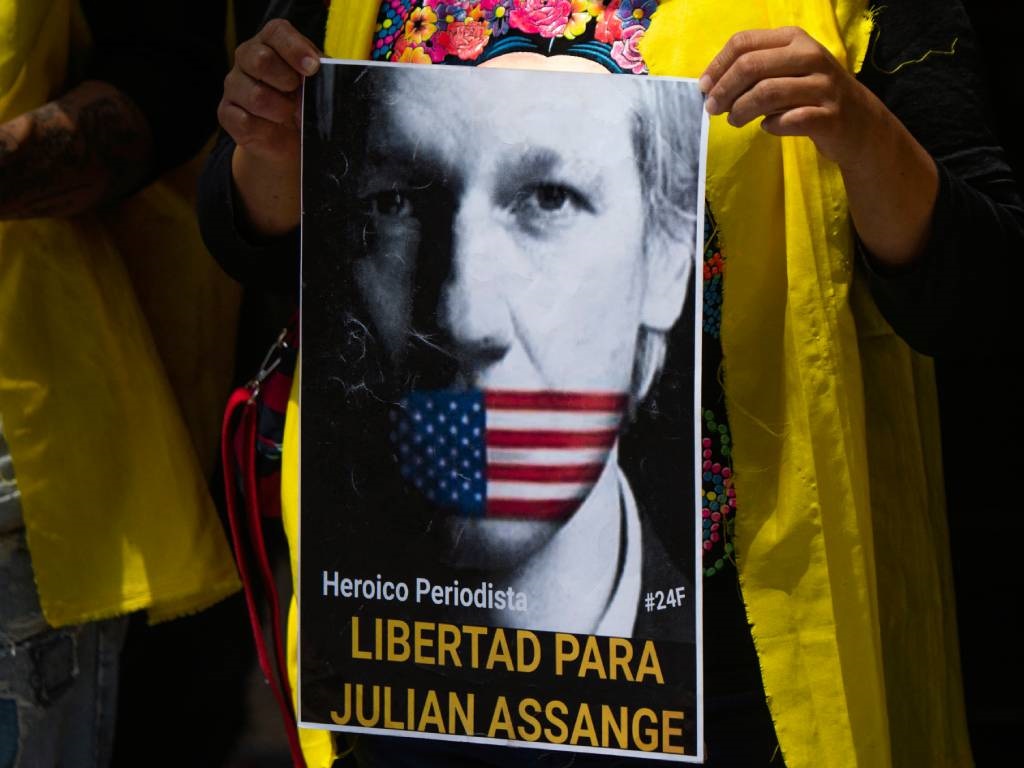 WikiLeaks'in kurucusunu tasvir eden bir poster tutan bir kadın