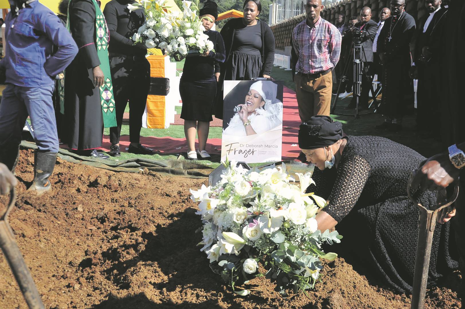 Left: Deborah Fraser’s sister Lorna laying a wreath on top of Deborah’s grave at Lala Kahle Cemetery. Top right: Musicians Tzozo Zulu and DJ Sox attended her burial. Right: Deborah’s coffin being lowered next to Bishop Vusi Dube during the funeral service at Lala Kahle Cemetery.