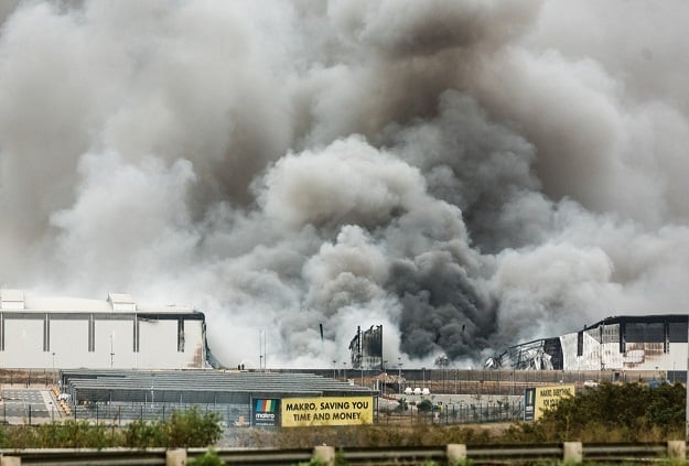 Smoke rises from a Makro building set on fire in Umhlanga, north of Durban, during the July unrest.