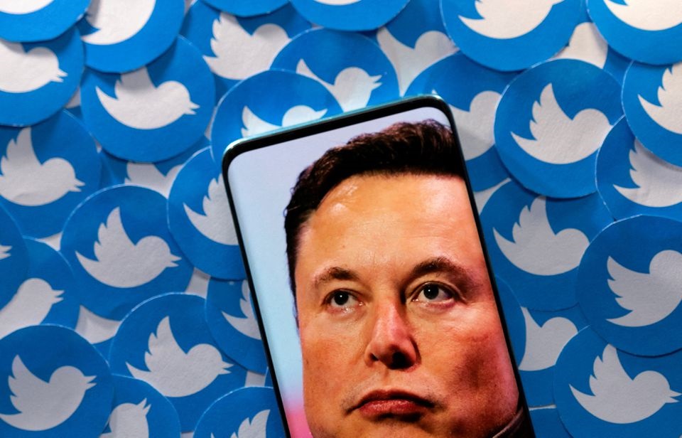 An image of Elon Musk is seen on smartphone placed on printed Twitter logos in this picture illustration taken April 28, 2022. REUTERS/Dado Ruvic/Illustration




