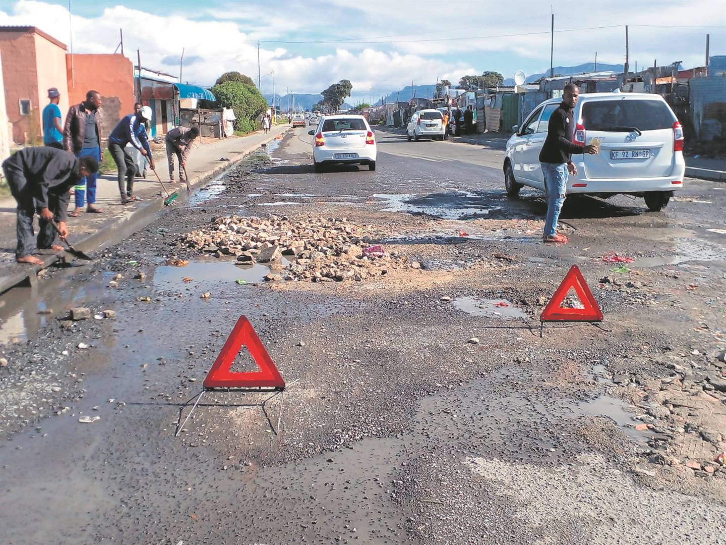 Young men fix potholes to curb smash-and-grab robberies in their kasi.   Photo by Lulekwa Mbadamane 