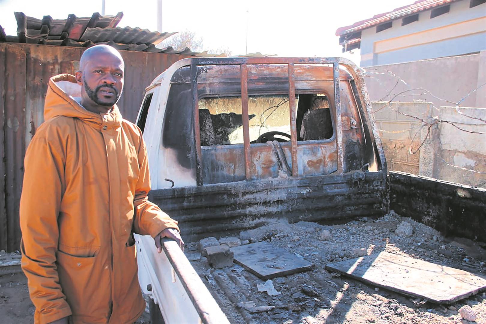 Samson Mkansi next to his burnt bakkie.    Photo by Phineas Khoza