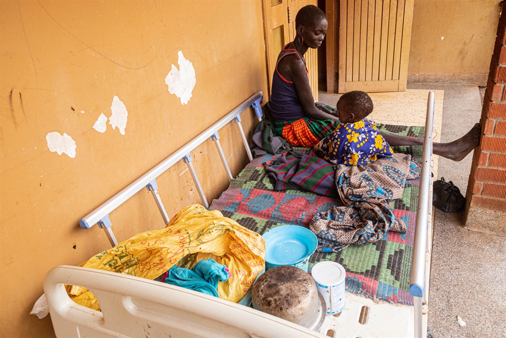A mother with her malnourished child sit on a bed at Moroto regional referral hospital in Moroto, Karamoja region, Uganda.