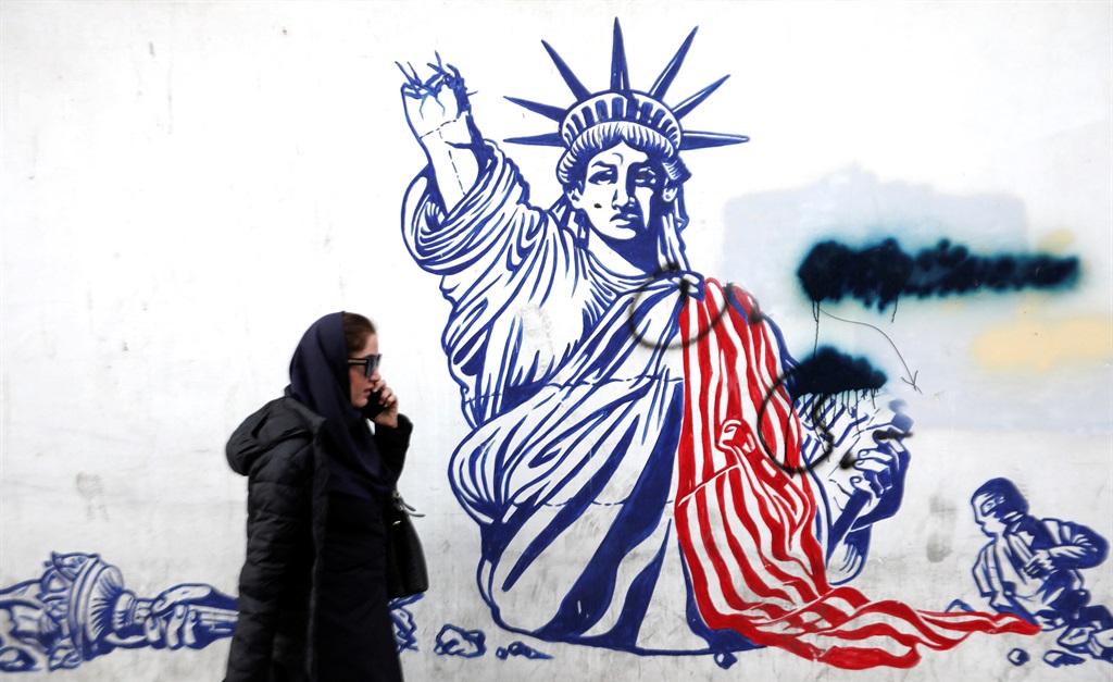 A woman walks past anti-US graffiti outside the building formerly hosting the embassy of the United States in Tehran - today known as the "Den of Spies" museum - on 30 January 2024, amid tensions between Iran and the US over the regional repercussions of the ongoing Israeli-Palestinian conflict. Following the killing of US troops on the Jordanian-Iraqi border that Washington blamed on Iran-backed groups on 28 January, Tehran has since denied any links to the attack and urged diplomacy while keeping vigilant of a possible US response.
