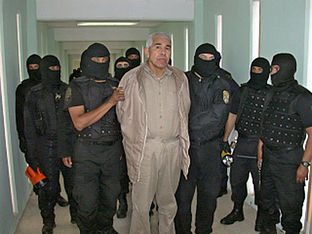 (FILES) In this file handout picture released by the Mexican Federal Preventive Police (PFP) on January 29, 2005, members of the PFP escort drug trafficker Rafael Caro Quintero, at the Puente Grande prion in Guadalajara, Jalisco State, Mexico.