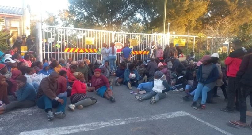 Protesting residents of the Covid informal settlement block the entrance to Driftsands Nature Reserve. A short while later they were dispersed by police. 