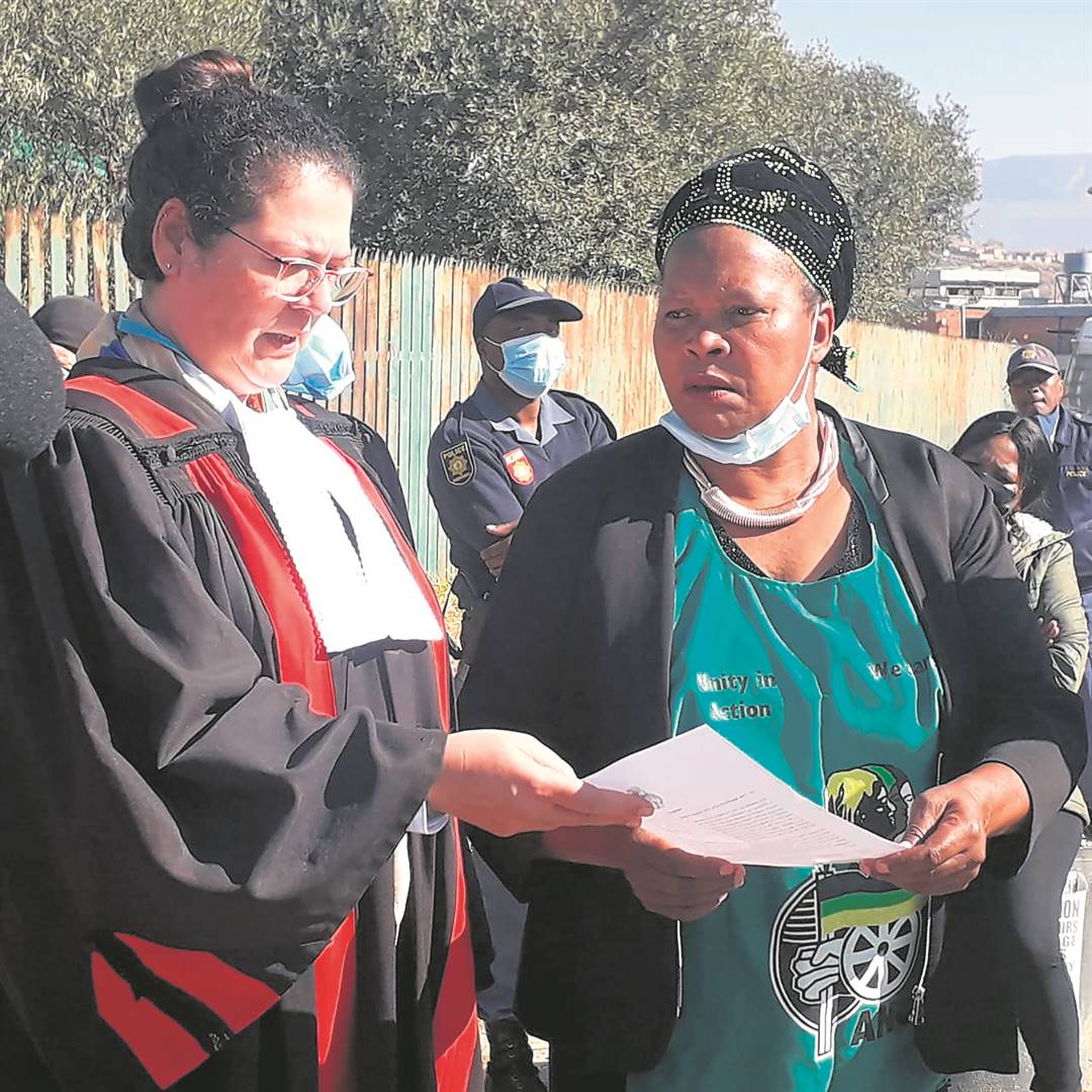 ANC Women’s League’s Masetjhaba Mosia-Lakaje hands over a memorandum to Thea Bakers to oppose bail in support of the victim’s family.     Photo by Joseph Mokoaledi