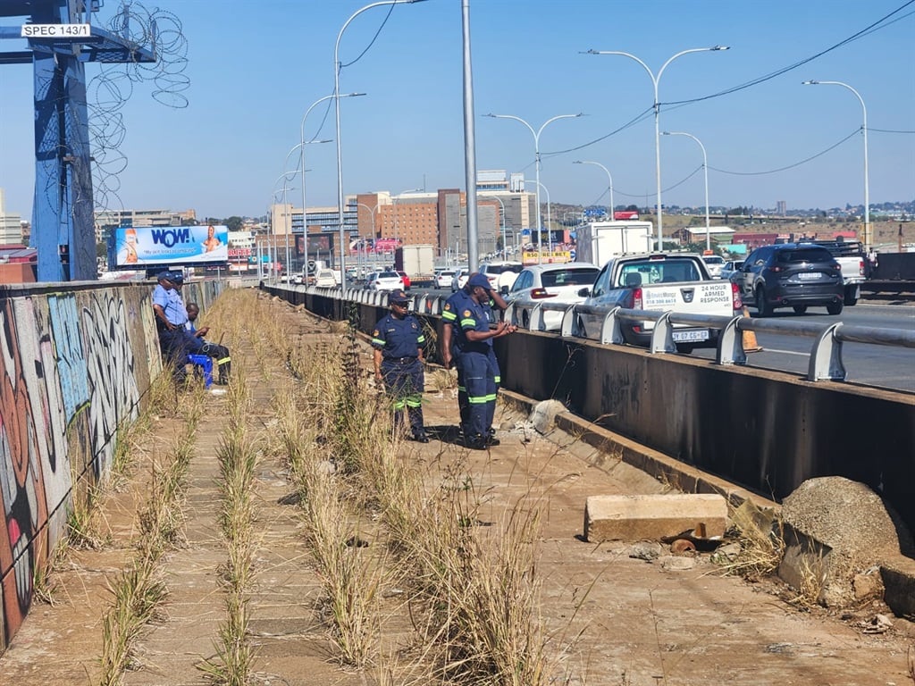 Johannesburg EMS teams inspect the M1 bridge to assess if it has cooled down enough to inspect the inside of the cavity for structural damage. (Alex Patrick/News24)