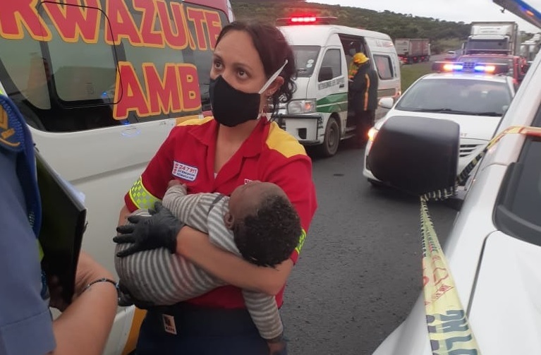 A paramedic comforts a child at the scene of the a