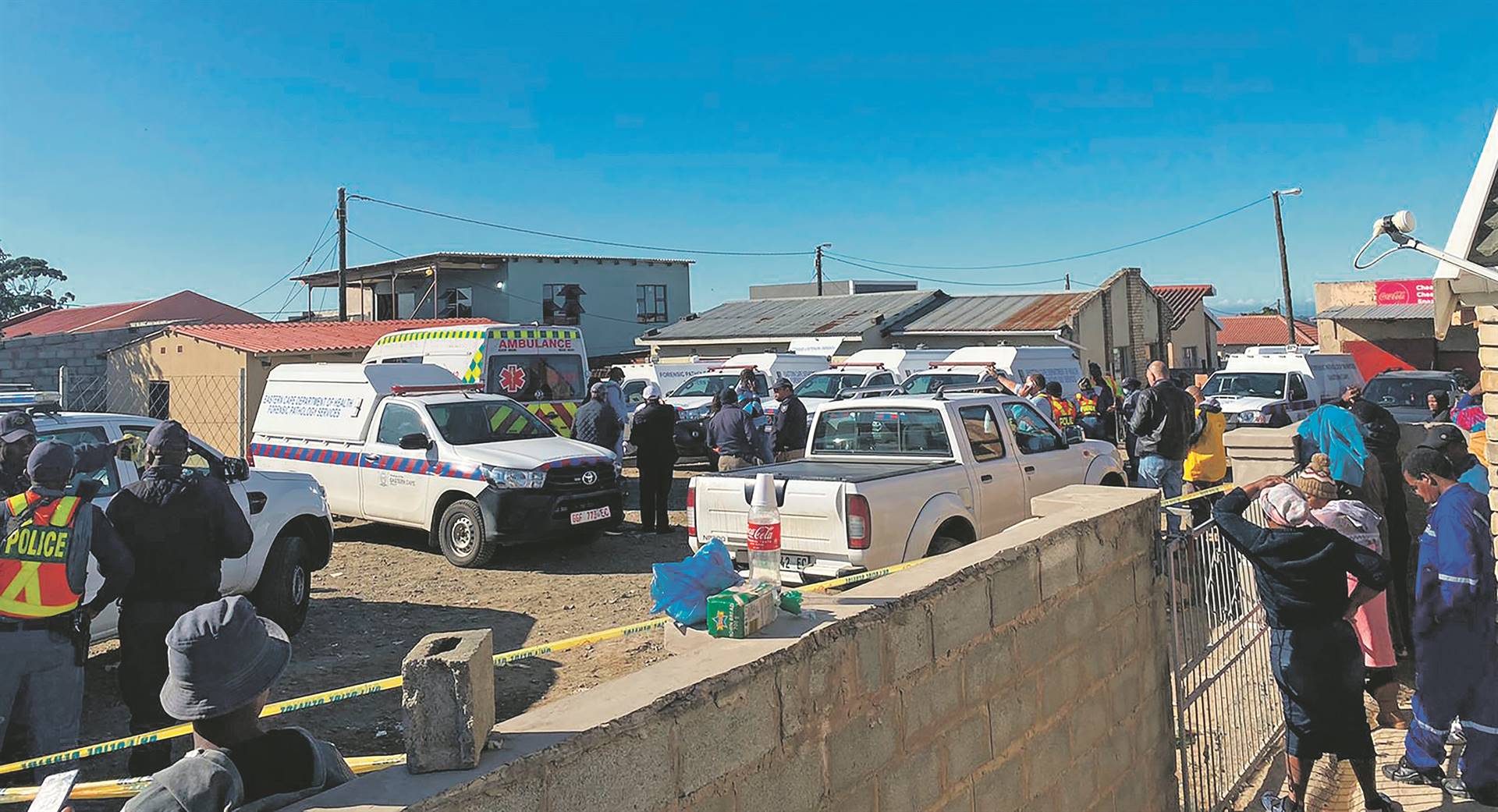 TAVERN TRAGEDY: Police are investigating after at least 21 young people died at a tavern in Scenery Park on Sunday, 26 June. Inset: Hundreds of community members gathered at the scene.                  Photos by Siphokazi Totyi