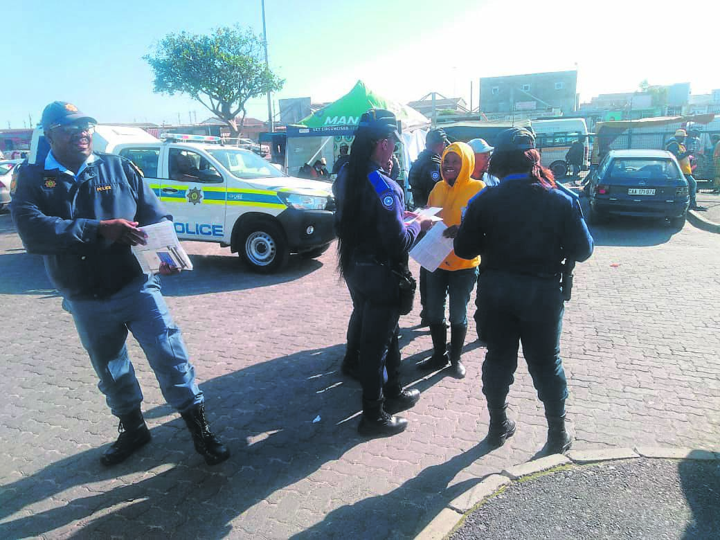 Police and law enforcement officers handing over pamphlets in Makhaza on Saturday 25 June.