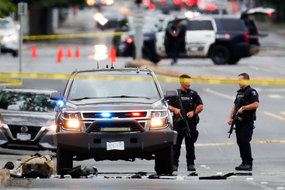 Police officers gather after two armed men entering a bank were killed in a shootout with police in Saanich, British Columbia, Canada June 28, 2022. REUTERS/Kevin Light



