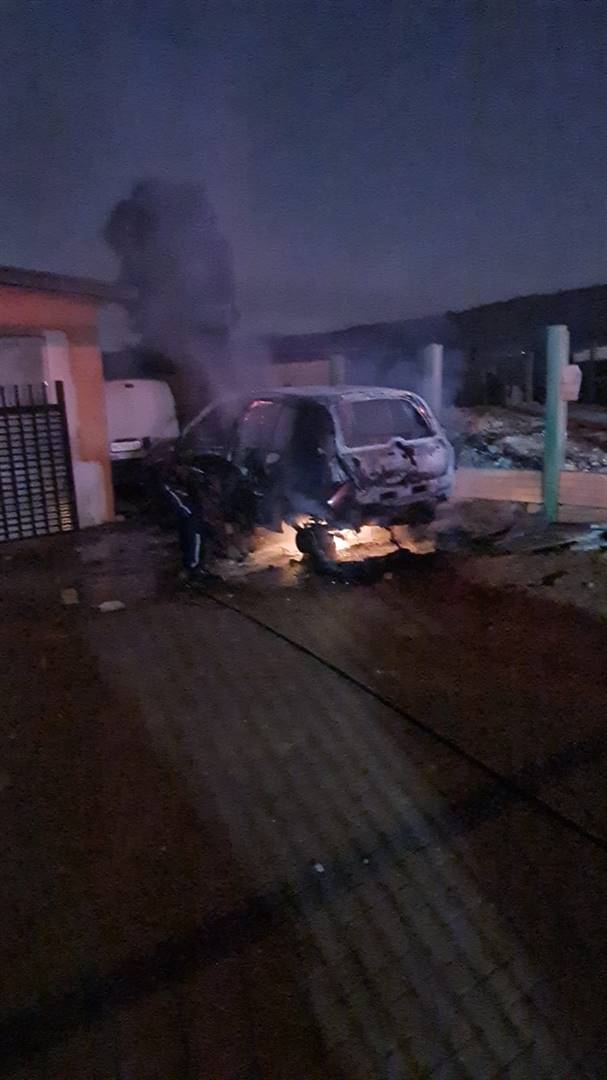 ’n Motor wat op die huiseienaar se erf in Pretoria geparkeer was, is Donderdagaand aan die brand gesteek en die huis is met klippe bestook. Foto: Verskaf