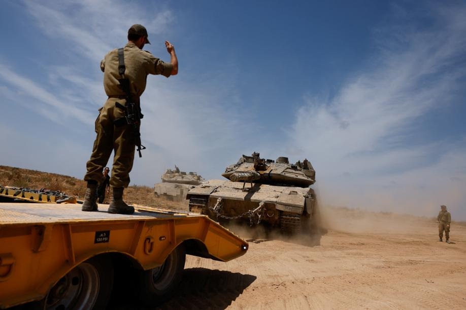 An Israeli soldier directs a tank, near the Israel-Gaza border, amid the ongoing conflict between Israel and the Palestinian Islamist group Hamas, in Israel, May 2, 2024. Photo by REUTERS
