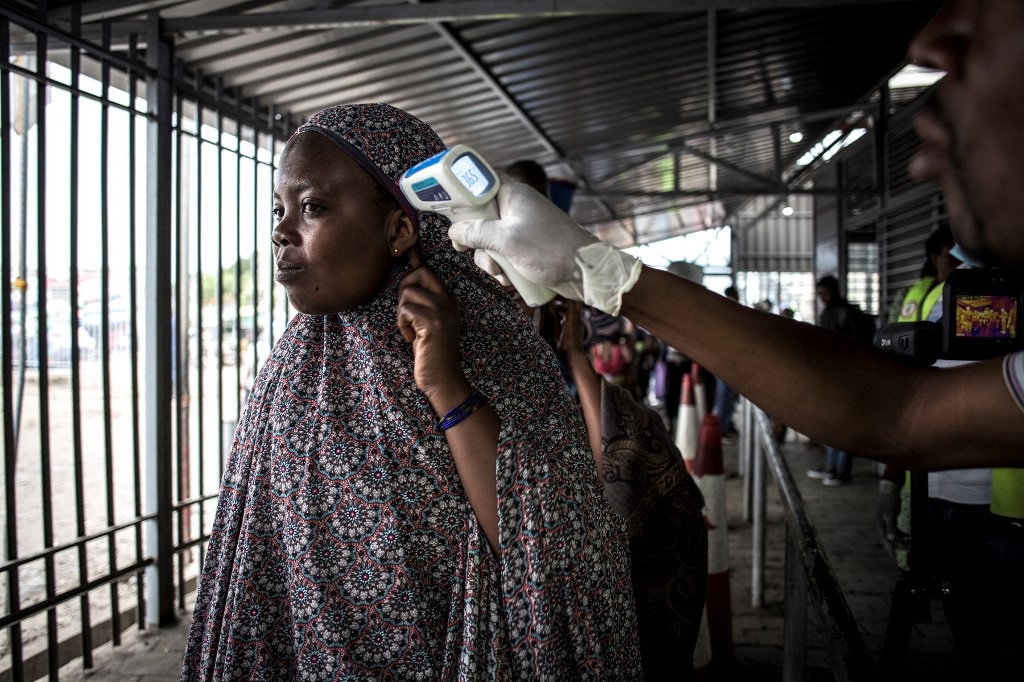 A woman gets her temperature measured at an Ebola 