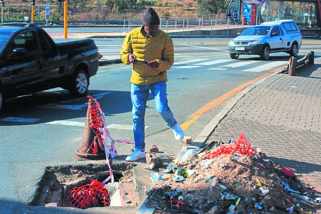 Sello Skhalo stands in front of one of the open holes in Diepkloof, which he fears children might fall into.       Photo by                            Thabo Monama