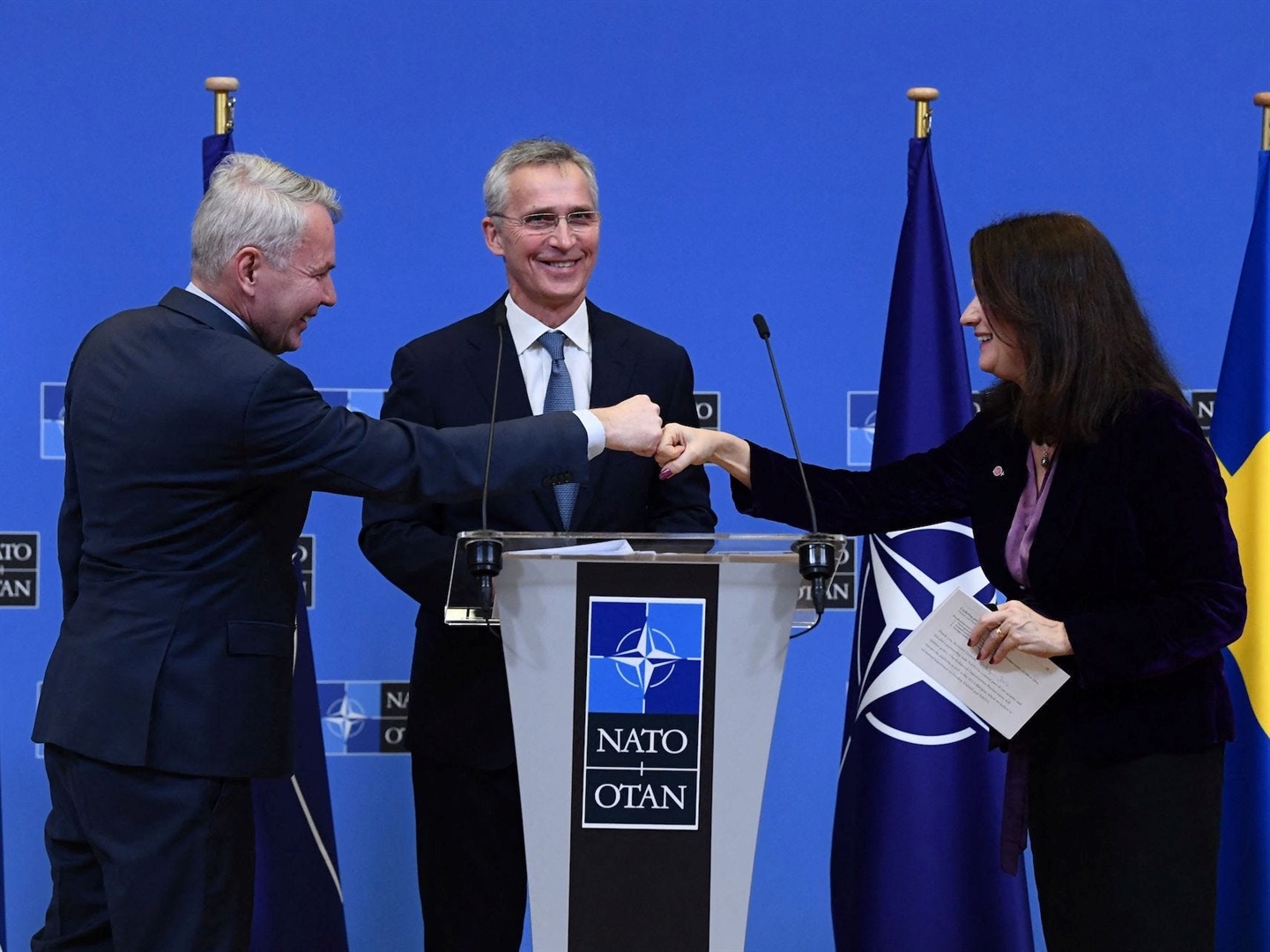 NATO Secretary General Jens Stoltenberg, centre, looks on as Finnish Minister for Foreign Affairs Pekka Haavisto, left, and Swedish Foreign Minister Ann Linde bump fists after a press conference at NATO headquarters in Brussels in January. JOHN THYS/AFP via Getty Images