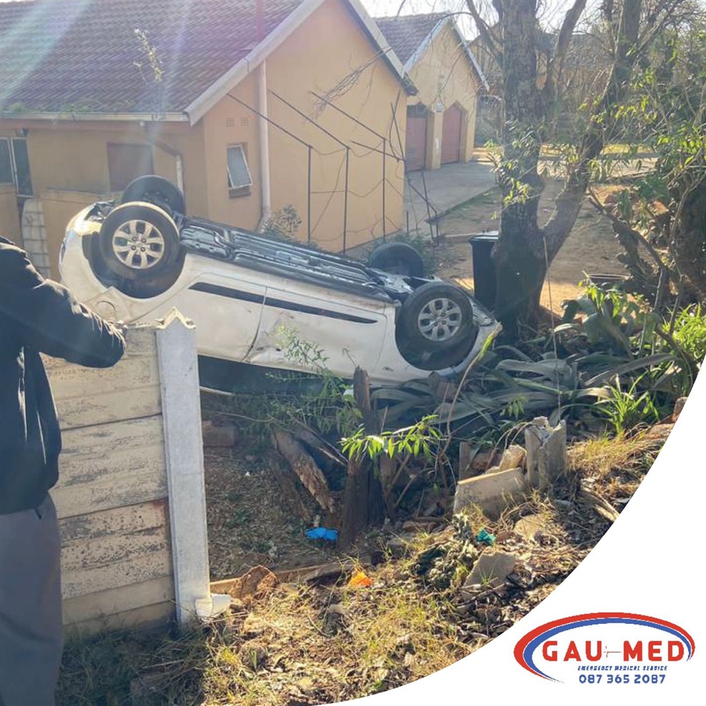 Car flipped on roof after crashing through wall
