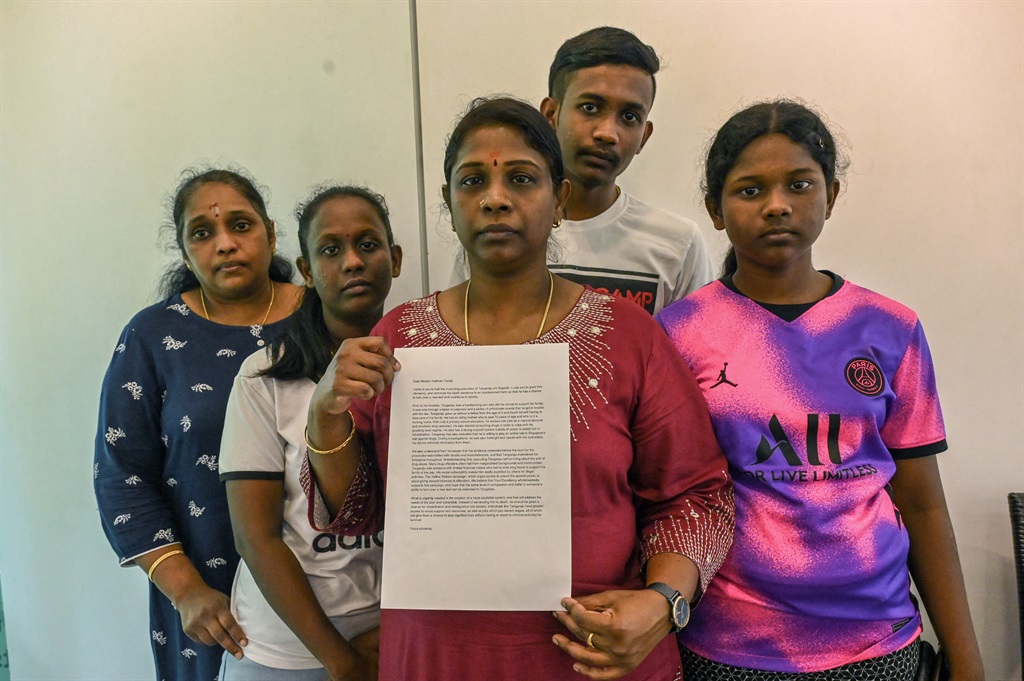 Leelavathy Suppiah (C), sister of a convicted drug trafficker Tangaraju Suppiah, who was executed in Singapore on Wednesday, poses with family members as she holds a petition letter used to seek clemency. 