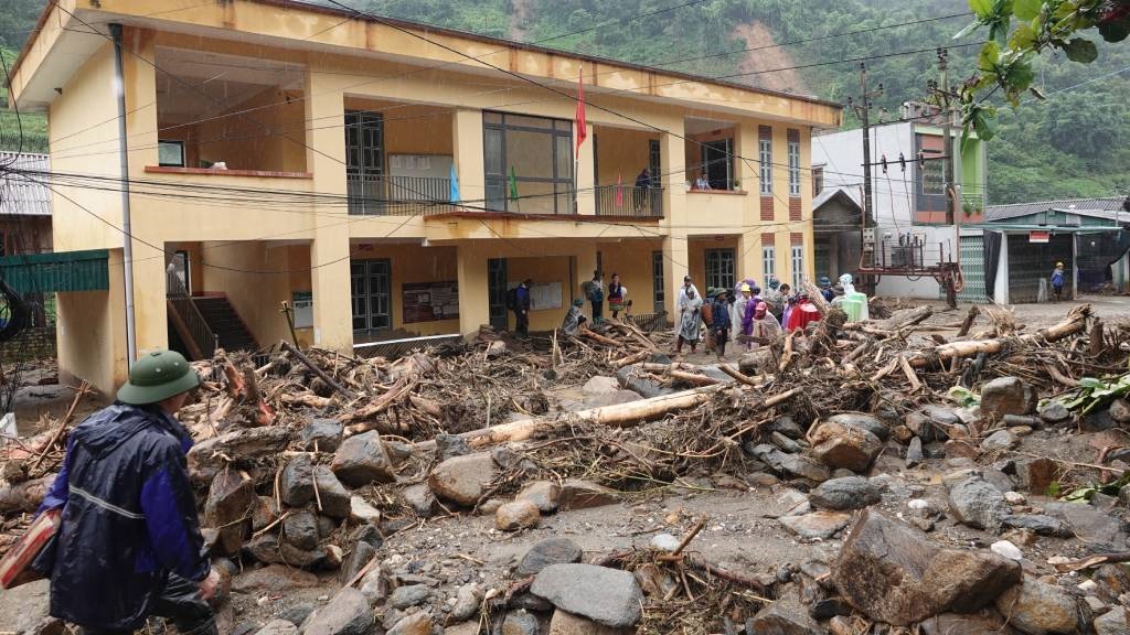 Residents remove debris after heavy rains caused f