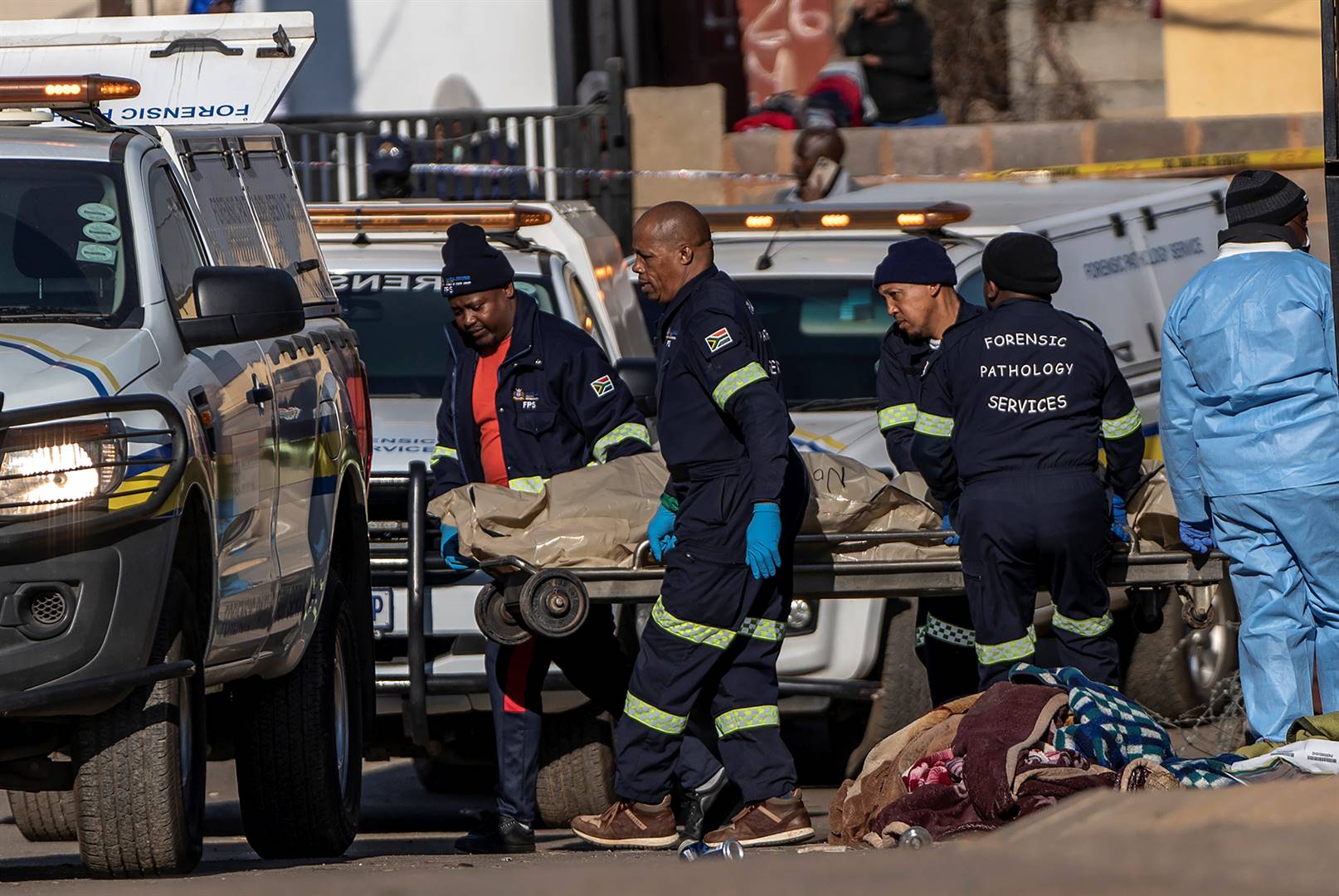 A body is removed from the scene of an overnight tavern shooting in Soweto on July 10. Photo: Shiraaz Mohamed/AP