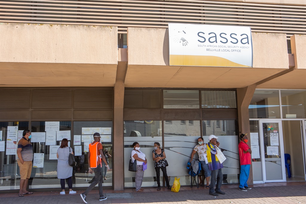 Grant recipients waiting in long queues at SASSA offices.
