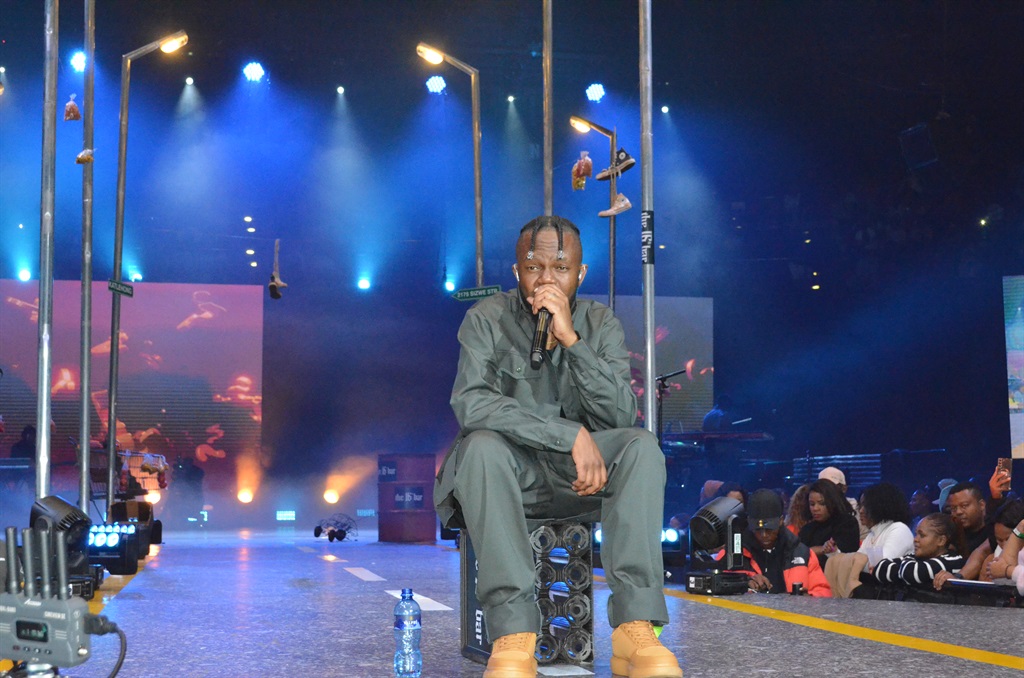 Kwesta sitting on the crate on the stage which had
