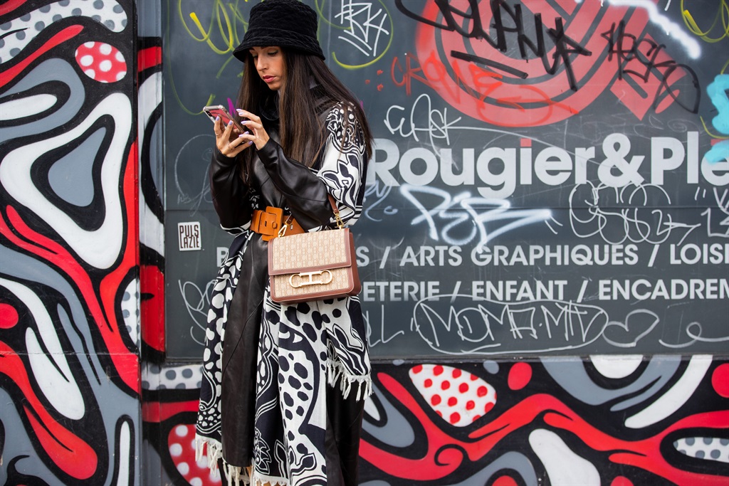 A guest is seen wearing a bucket hat, belted coat, Dior bag outside GAUCHERE during Paris Fashion Week - Womenswear Spring Summer 2021: Day Three in Paris, France. Photo by Christian Vierig/ Getty Images