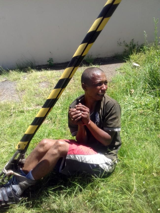 This man who was allegedly caught stealing was tied to an electric pole, doused with petrol and left in the scorching hot sun. Photo by Zamokuhle Mdluli